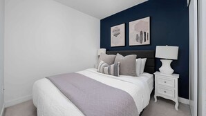 A bedroom with a bed, nightstands, and wall art. - Walk to Rogers Centre, CN Tower, Waterfront! (Toronto)