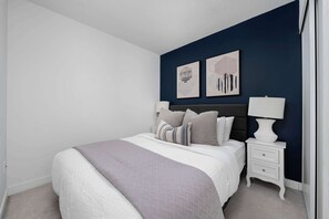 Ein Schlafzimmer mit einem Bett, Nachttischen und Wandbildern.