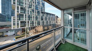 A modern building with large windows and a balcony overlooking a street with a Christmas wreath. - Walk to Rogers Centre, CN Tower, Waterfront! (Toronto)