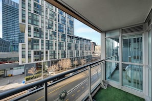 Ein modernes Gebäude mit großen Fenstern und einem Balkon mit Blick auf eine Straße, geschmückt mit einem Weihnachtsgesteck.