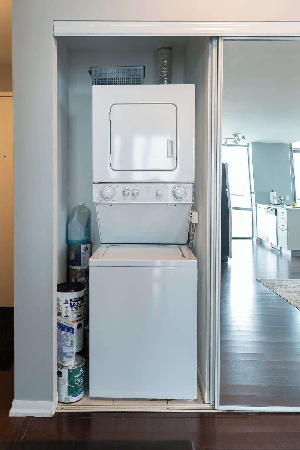Een kleine wasruimte met een wasmachine en droger, een waterdispenser en opslagblikjes.