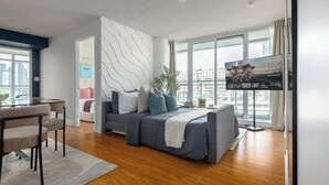 Uma sala de estar moderna com um sofá, uma mesa de centro de vidro e uma televisão.