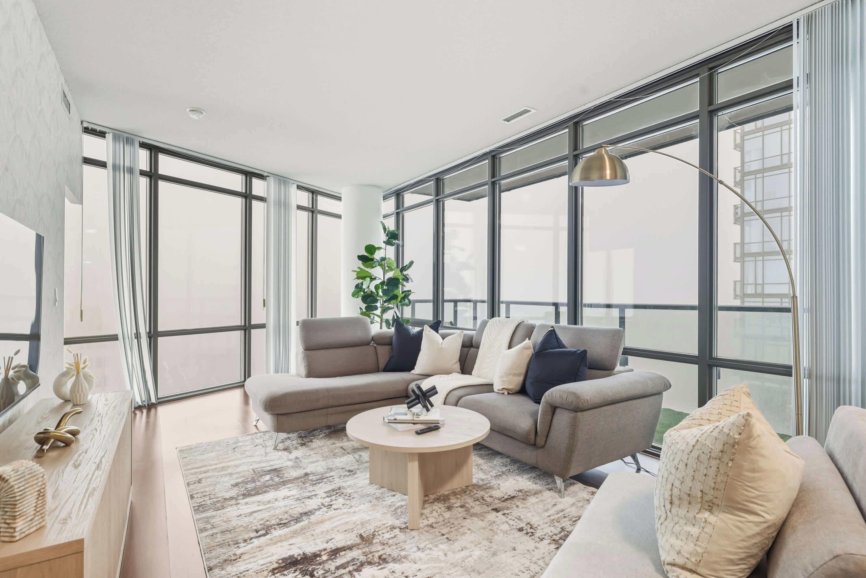 Een moderne woonkamer met een modulaire bank, een salontafel en een groot raam met uitzicht.