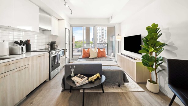 A modern apartment with a kitchen, dining area, and a balcony with a city view. - City Living Downtown Retreat Perfect Getaway! (Toronto)