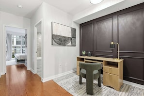 A modern home office with a desk, chair, and a large painting on the wall. - Luxury DT Townhome Steps to Top Attractions! (Toronto)