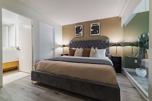 A modern bedroom with a large bed, a tufted headboard, and a bedside table with a lamp. - Luxury Waterfront Escape Stylish 3BR Condo | Parking Available (Toronto)