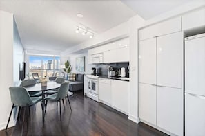 A modern kitchen with white cabinets, a black countertop, and a built-in oven. - Downtown Central - Rogers Centre - 3 beds - Views (Toronto)