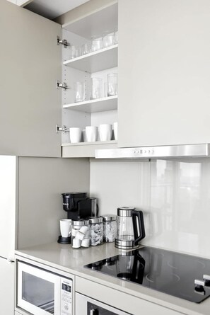 A modern kitchen with built-in cabinets, a stainless steel range hood, and a coffee maker. - Luxury 2BR Suite in Heart of Toronto Entertainment (Toronto)