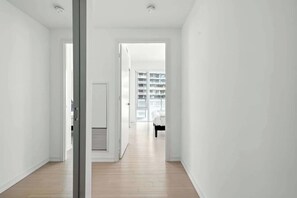 A hallway with a door leading to a room with a bed and a window. - Luxury 2BR Suite in Heart of Toronto Entertainment (Toronto)