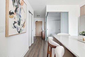 Une cuisine moderne avec un plan de travail blanc et des tabourets en bois.