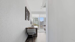 A modern interior with a dining area, a sofa, and a view of the cityscape through large windows.