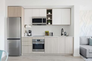 Une cuisine moderne équipée d’un four à micro-ondes, d’un four et d’un réfrigérateur encastrés.