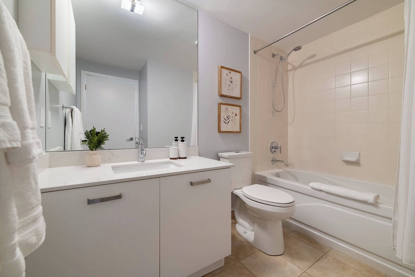 A modern bathroom with a sink, toilet, and bathtub.