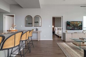 Ein zeitgemäßer Wohnbereich mit Essbereich, Küche und Fernseher im Wohnzimmer.