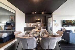 A modern interior with a dining area, kitchen, and living space. - Elevated Downtown 3BR w Views & Free Parking (Toronto)