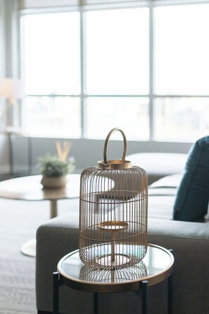 A metal birdcage with a handle on a small round table in a room with a sofa and a window. - Elevated Downtown 3BR w Views & Free Parking (Toronto)