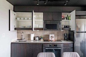 A modern kitchen with a built-in microwave, oven, and refrigerator. - Elevated Downtown 3BR w Views & Free Parking (Toronto)