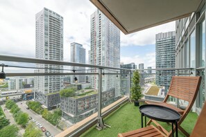 A balcony with a view of high-rise buildings, a small table, and a chair. - Chic 2BR Downtown King Suite Parking Sleeps 6 | Parking Available (Toronto)