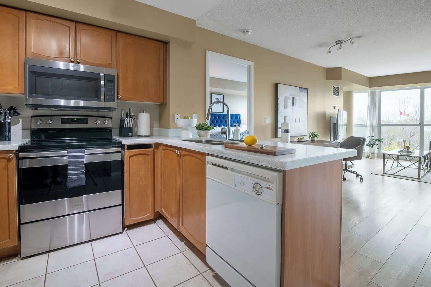A modern kitchen with stainless steel appliances, wooden cabinets, and a central island.