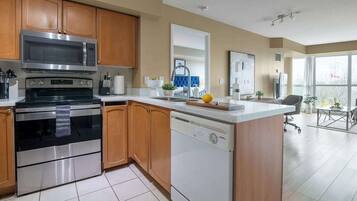 A modern kitchen with stainless steel appliances, wooden cabinets, and a central island.