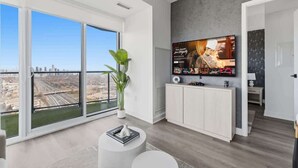 A modern living room with a large window, a flat-screen TV, and a minimalist design.