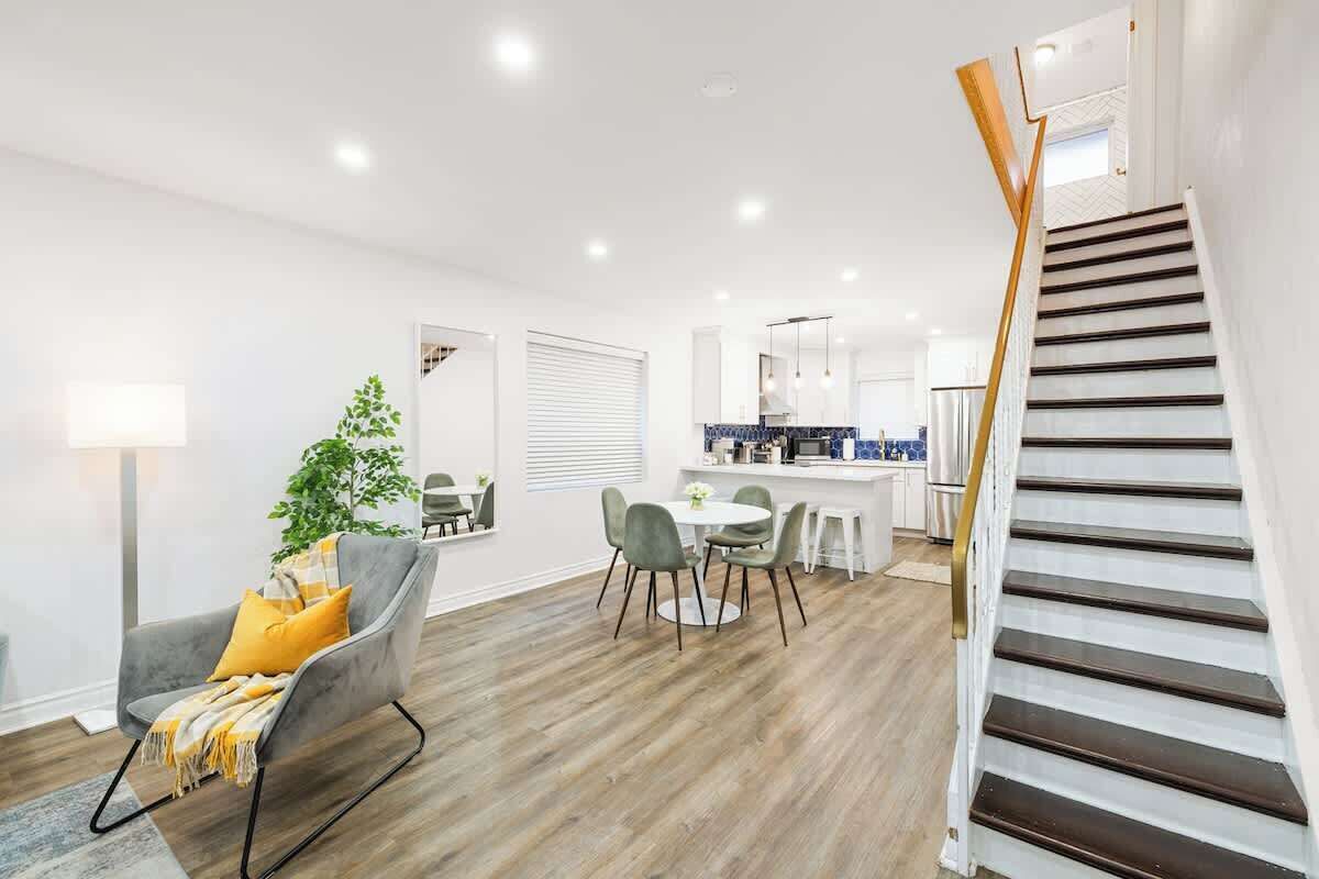 Un interior moderno con comedor, escalera y cocina.