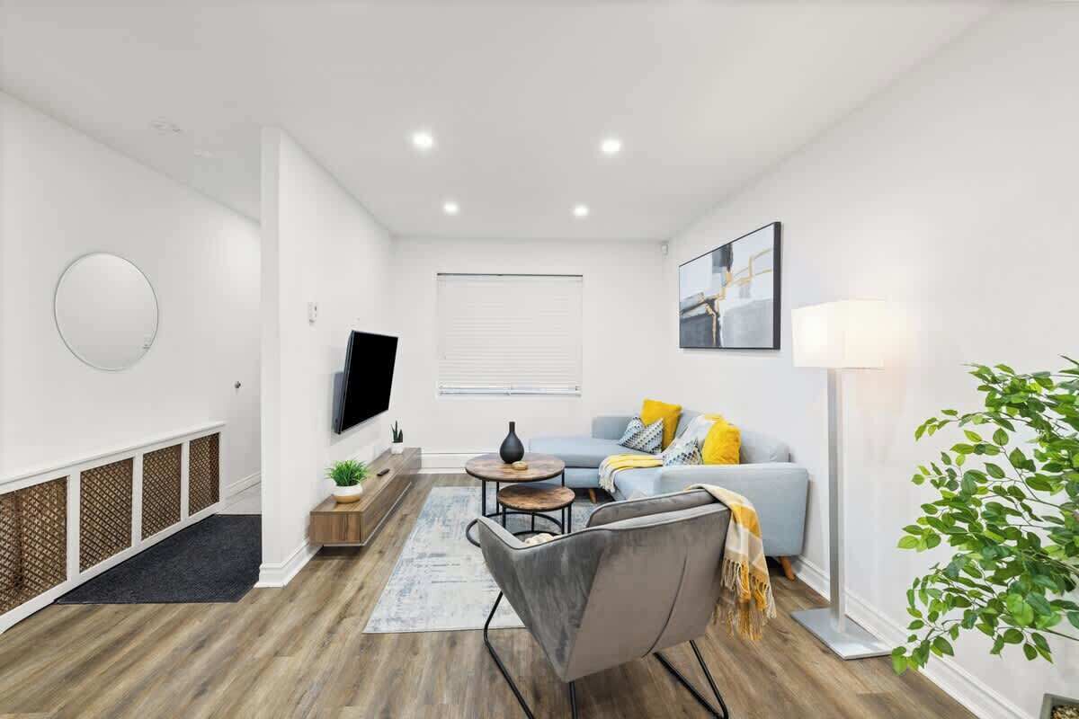Uma sala de estar moderna com sofá, mesa de centro e televisão.