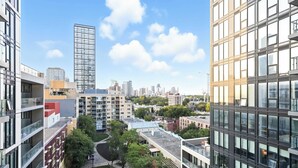 Um edifício alto com design moderno, apresentando várias varandas e janelas amplas.