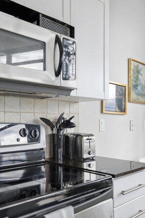 A kitchen with a microwave, toaster, and stainless steel appliances.