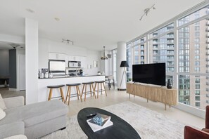 A modern apartment with a kitchen, dining area, and living room. - Luxury 2BR Condo with King Beds & Views | Parking Available (Toronto)