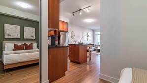 Un intérieur moderne comprenant un lit, un coin cuisine et un espace repas.