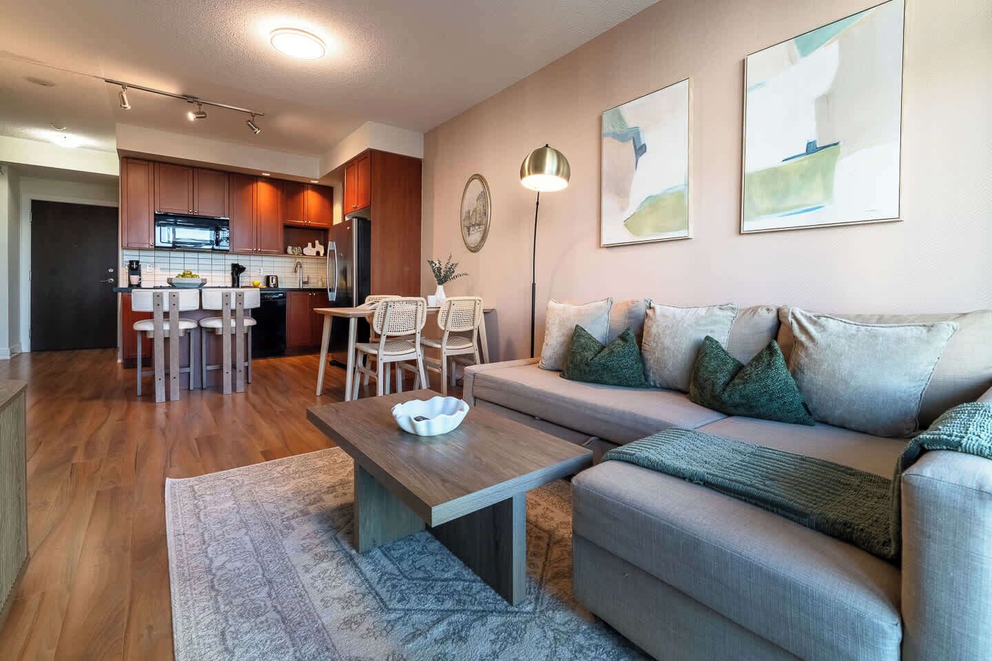 A modern living room with a sofa, coffee table, and dining area.