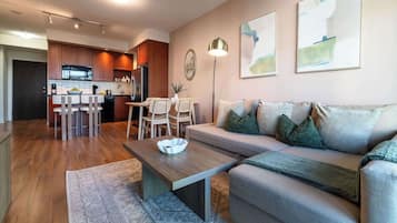 A modern living room with a sofa, coffee table, and dining area.