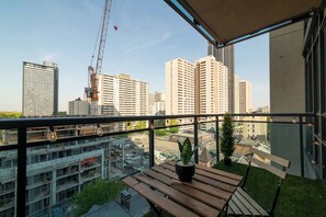 A balcony with a view of a cityscape, including high-rise buildings and construction cranes. - Elegant 2BR Condo in Prime Downtown Location | Parking Available (Toronto)