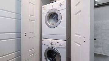 A stacked washer and dryer unit in a utility room.