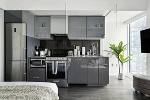 A modern kitchen with a built-in oven, microwave, and coffee maker. - Modern City Retreat in the Heart of Toronto | Parking Available (Toronto)
