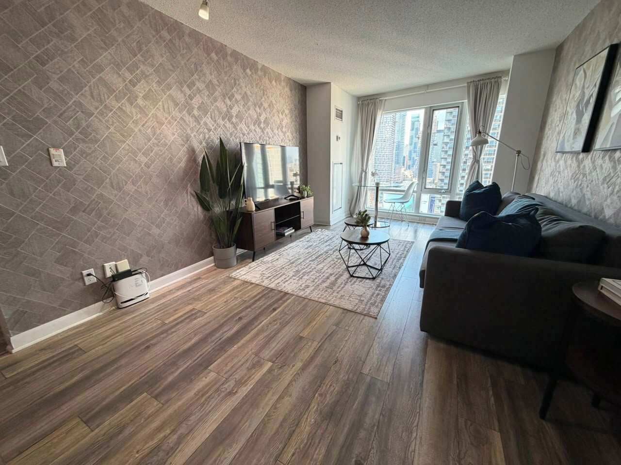 A modern living room with a sofa, a coffee table, and a TV.