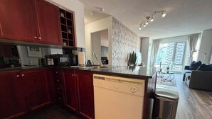 A modern kitchen with a dishwasher, a sink, and a trash bin.