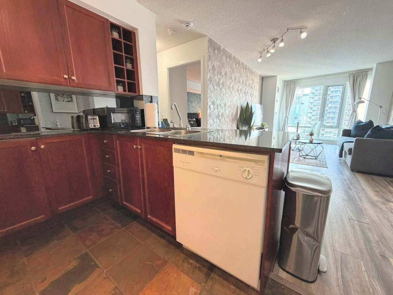 A modern kitchen with wooden cabinets, a dishwasher, and a sink.