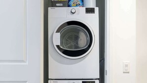 Un lavadero pequeño con dos puertas, que cuenta con lavadora y secadora integradas.