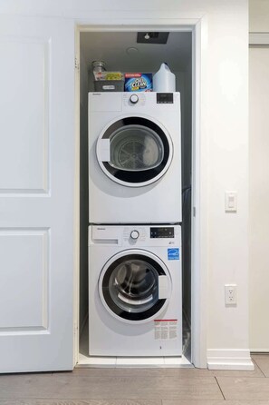 Ein kleiner Hauswirtschaftsraum mit zwei Türen, inklusive Waschmaschine und Trockner.