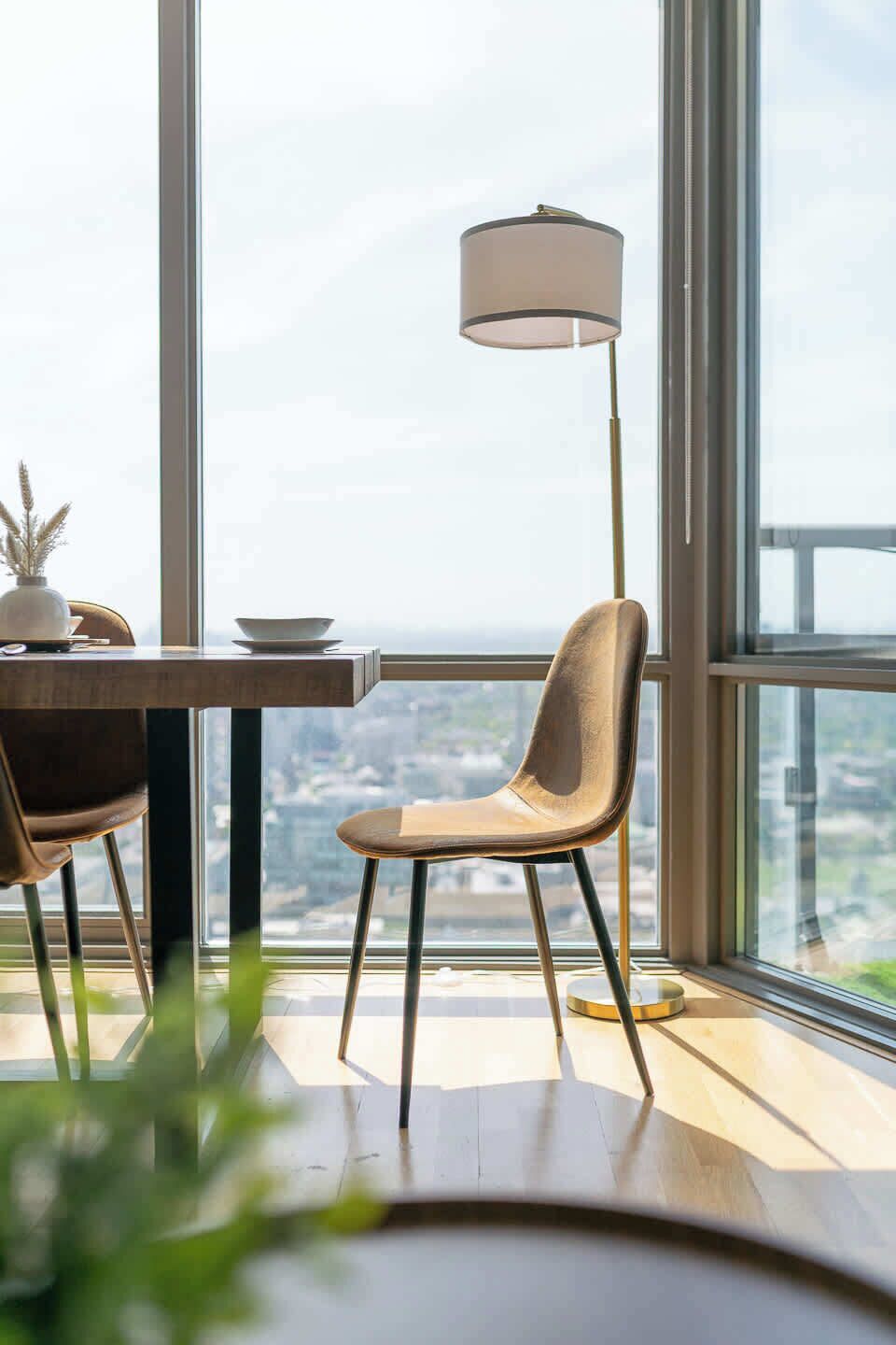 A modern dining area with a table, chairs, and a floor lamp.