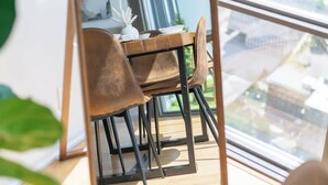 A dining area with a table and chairs, a lamp, and a view of the city through large windows. - Financial District 3BR CN Tower Views! (Toronto)