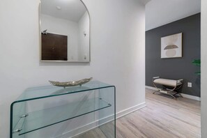Ein modernes Badezimmer mit einem Glas-Waschtisch, einem großen Spiegel und einer dunklen Akzentwand.