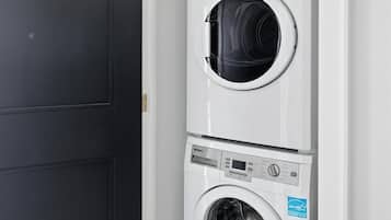 A compact, two-door laundry room with a black door and a white interior.