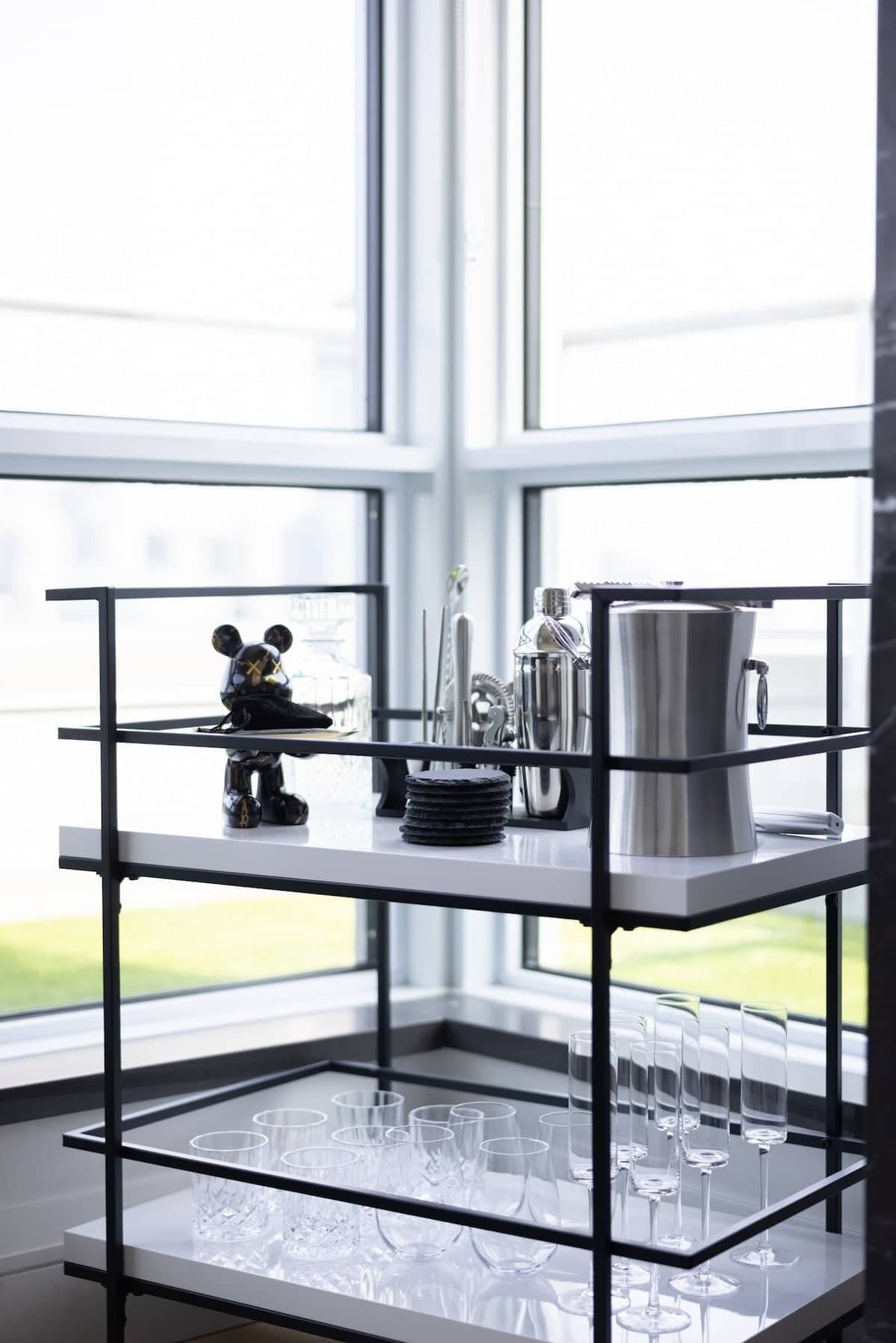 Ein Eckregal mit einer Mickey Mouse-Figur, einer silbernen Karaffe und gestapelten Untersetzern.