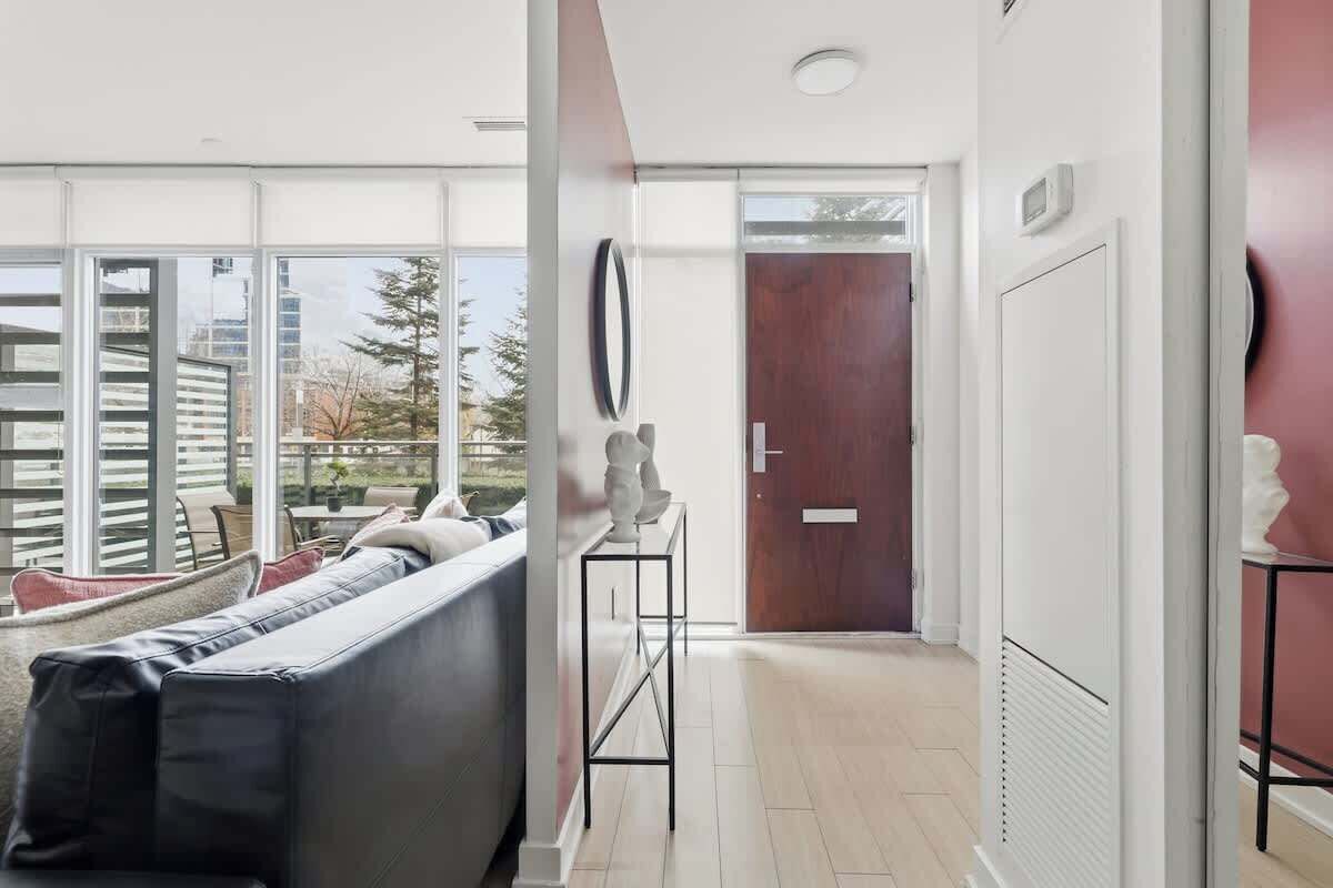 A modern living room with a sofa, a small table, and a door leading to another room.