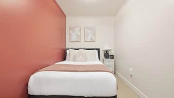 Une chambre à coucher avec un lit, une table de chevet et des œuvres d’art murales.