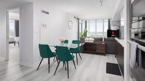 Eine moderne Wohnung mit Essbereich, einer Küchenzeile und einem Wohnraum mit großem Fenster.