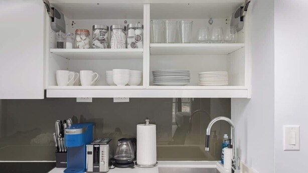 Eine Küchenzeile mit Kaffeemaschine, Toaster, Wasserkocher und Spüle.